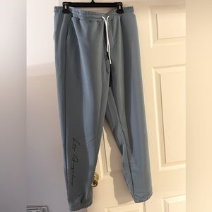 Dusty blue sweat pants “LOS ANGELS” down the leg.